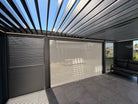Open louvers and lighting detail in an illustrative pergola configuration with optional screen; side slat panels and furniture not included